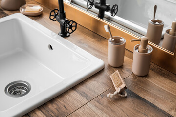 Bath accessories and sink on table near mirror, closeup