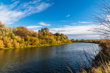 Calm flat river on a sunny autumn day.