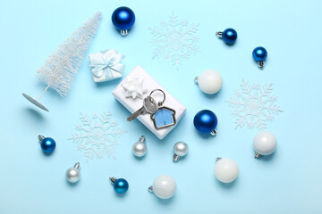 Christmas gifts with key from new house and decor on blue background