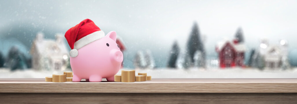 Pink piggy bank with santa claus hat on a table - saving concept for christmas
