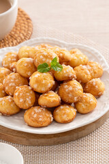 Delicious French Chouquette Choux Pastry dessert Pearl Sugar Puff on wooden table background.