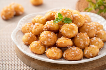 Delicious French Chouquette Choux Pastry dessert Pearl Sugar Puff on wooden table background.