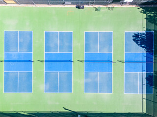 Top view from the sky of blue and green tennis court with nets