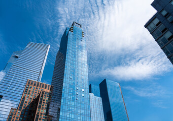 Cubes of skyscrapers made of glass and concrete leaving their tops in the blue sky