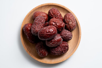 Jujube, Chinese red dates top view on wooden circle plate with isolated white background