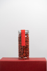 Dried wolfberry, goji berries in transparent plastic bottle isolated with white background