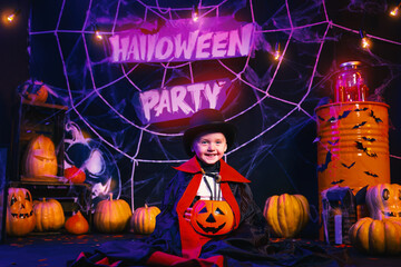 Halloween concept. Emotional boy in vampire costume having fun at the party in decoration zone