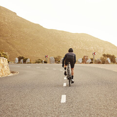 Fitness, cycling and sports man on a bicycle at sunset with mountain view in South Africa,...