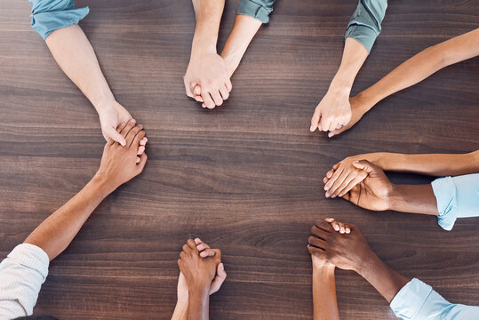 Top view, holding hands or mental health support in group therapy meeting for psychology, trust or security. Men, women and diversity people in prayer circle for community, anxiety or depression help