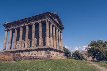 Fototapeta na wymiar Temple of Garni in Armenia picturesque photo with the blue sky in the background and no people around. Ruins of ancient Armenian temple. Armenia landscape attraction.