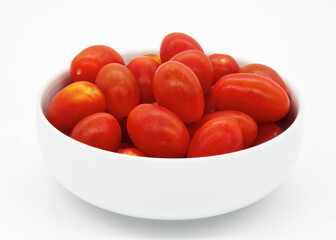 Red cherry tomatoes in a bowl isolated on white background.