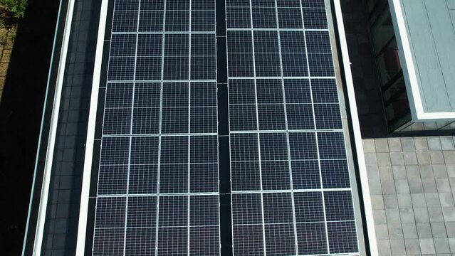 Aerial view over a air ventilation system and photovoltaic cells on a rooftop - high angle, drone shot