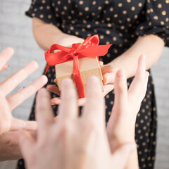 Woman holding a gift box tied with a red ribbon