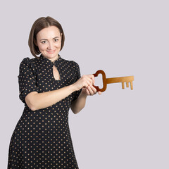 Portrait of a beautiful middle-aged brunette woman with a big key in her hands, the concept of discovery and knowledge
