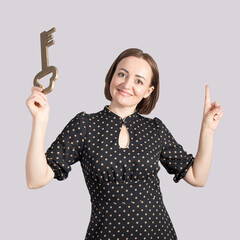 Portrait of a beautiful middle-aged brunette woman with a big key in her hands, the concept of discovery and knowledge