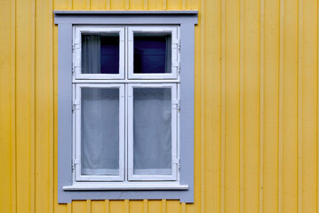 Fototapeta na wymiar closeup on window on a facade of a sweden house painted in yellow