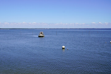 water ocean beach in Cap Ferret near arcachon city in France with oyster boat and buoy