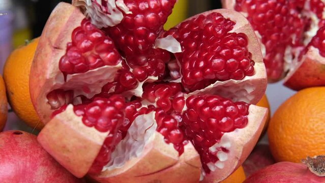 Open large juicy ripe pomegranate on the showcase of a shop in freshly juices