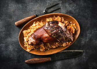 Baked Eisbein with stewed cabbage. Smoked pork ham hock, pork knee served with sauerkraut. - obrazy, fototapety, plakaty