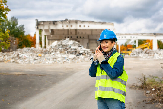Female architect talking on the phone at a construction site. 