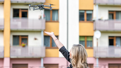 Fototapeta na wymiar drone landing on hands of young blonde woman, modern technology concept