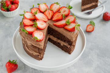 Naked chocolate cake with cream and fresh strawberries on top. Rustic style. Selective focus. Copy space.