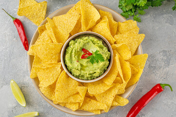 Mexican Nachos chips and dip sauces. Tortilla corn nachos chips with tomatoes salsa and guacamole. Top view.