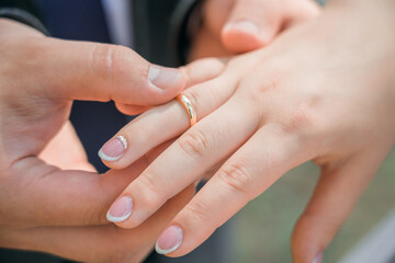 Obraz na płótnie Canvas Newlyweds put wedding rings on their finger. Close-up.