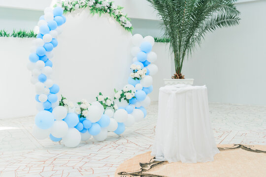 Decoration of the photo zone with balloons and a press- ox in the form of a circle. Balloons of blue and white color in the design of the photo zone.