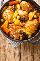 Gallo en chicha is a traditional chicken dish that is popular in El Salvador, as well as in other Central American countries closeup on the pan on the wooden table. Vertical top view from above