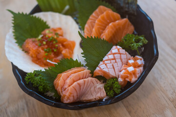 Fresh sliced salmon or salmon sashimi with salmon ikura or salmon egg in bowl set on table, Japanese food.
