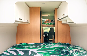 Young woman sleeping alone on camper van bunk bed