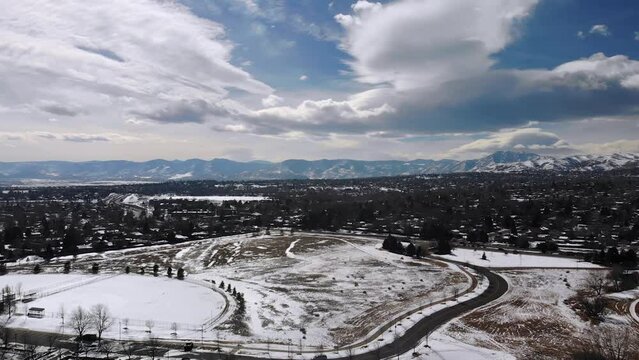 Beautiful Shot of Rocky Mountains with Cloudy Sky During Winter • Suburban Snowy Park in Colorado • Descending Aerial Drone Shot in Horizontal HD