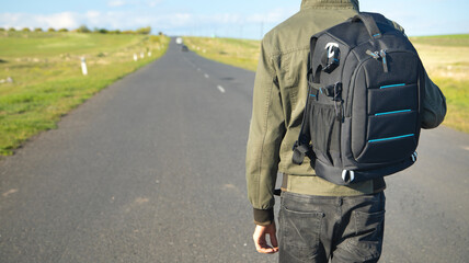 Man with backpack standing on the road.