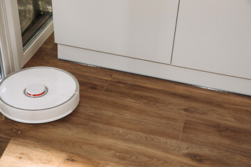 Robot vacuum cleaner does house cleaning close-up. Use of modern technology for cleaning. Top view