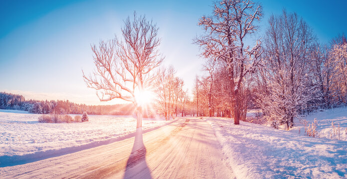 Beautiful view of the sunrise in the morning on the country snowy road.
