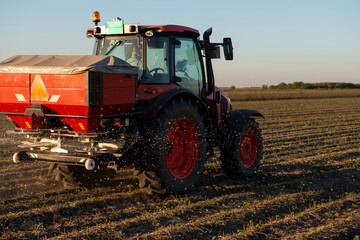 Fototapeta premium Tractor spreading artificial fertilizers