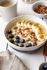 Oatmeal with banana, blueberries, almonds and honey. Healthy food. Vegetarian food. Breakfast.