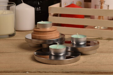 Podgrzewacze zapachowe na ekspozytorze na stole ze świeczkami i drewnianym koszykiem w tle