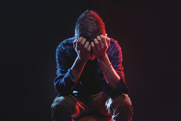 Helpless, hurt, depressed young man feeling completely crushed, dramatic studio portrait - 539404910