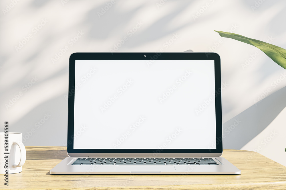 Poster designer office desktop with empty white laptop display with mock up place in frame, concrete wall b
