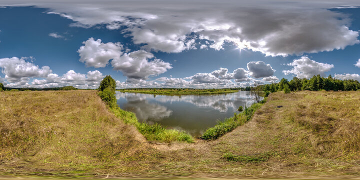 full seamless spherical hdri 360 panorama view on grass coast of huge lake or river in sunny summer day and windy weather with beautiful clouds in equirectangular projection, VR content