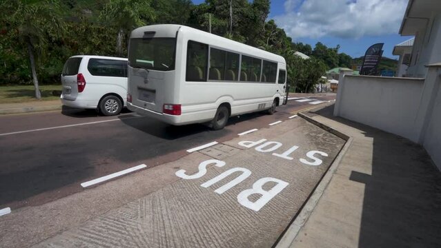 Public bus slowly driving past bus stop in Seychelles