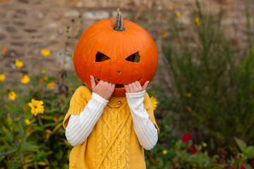Child with pumpkin on head, Halloween theme