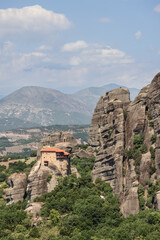 Fototapeta na wymiar Vertical shot of The Holy Monastery of Saint Nicholas of Anapafsas, the first Monastery that tourists encounter on their way to the Holy Meteora, Greece
