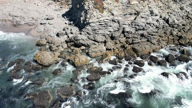 Aerial view of the rocky shore of Bodega Bay with the splashing Pacific Ocean
