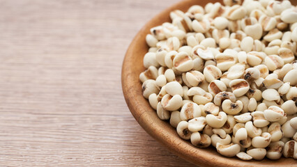 Jobs tear seed or coix millet seed grain in wood plate isolated on white background. heap of Jobs tear or coix millet seed grain isolated. Jobs tear or millet coix seed