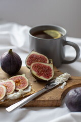 sliced figs on a wooden board and a cup of lemon tea