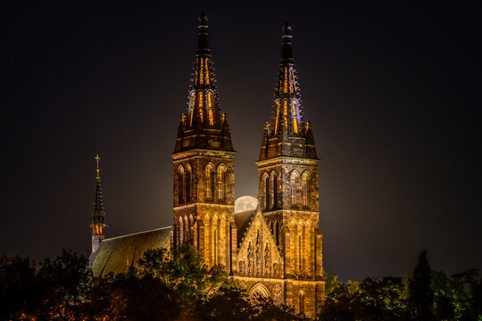 Full moon over the illuminated Basilica of St. Peter and St. Paul on Vysehrad hill in Prague.