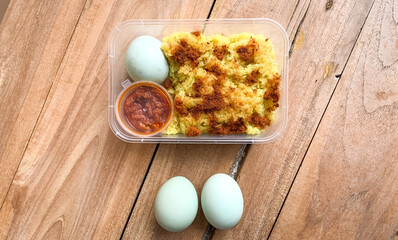 Yellow sticky rice with fish floss, sambal and salted egg as side dish topping.